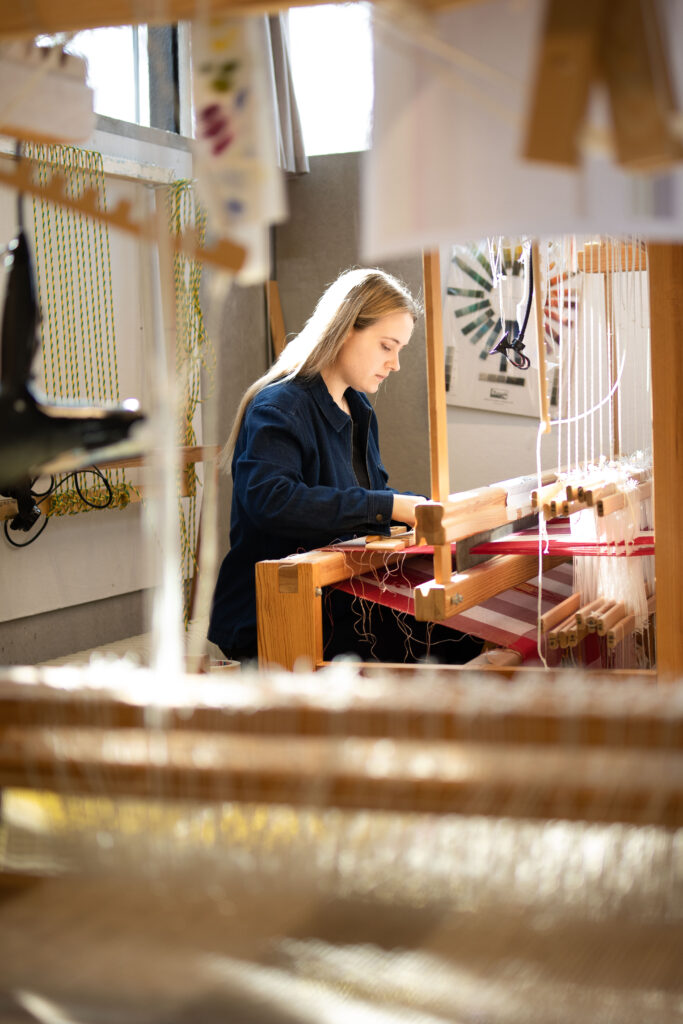 Bild på kvinna vid vävstol